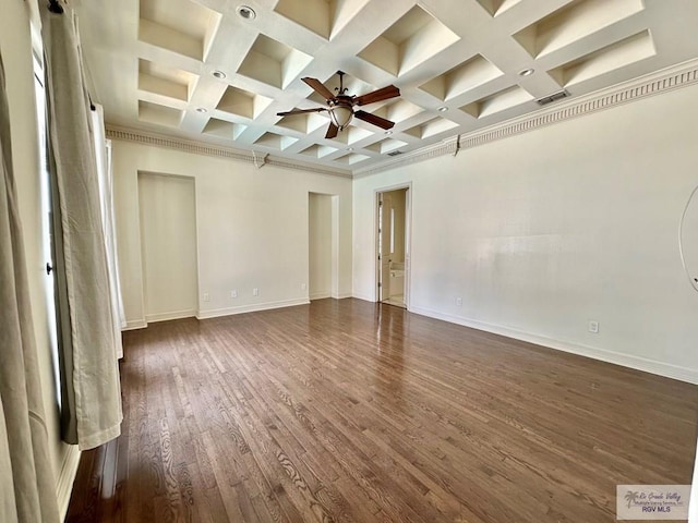 empty room with dark hardwood / wood-style flooring, coffered ceiling, ceiling fan, crown molding, and beam ceiling