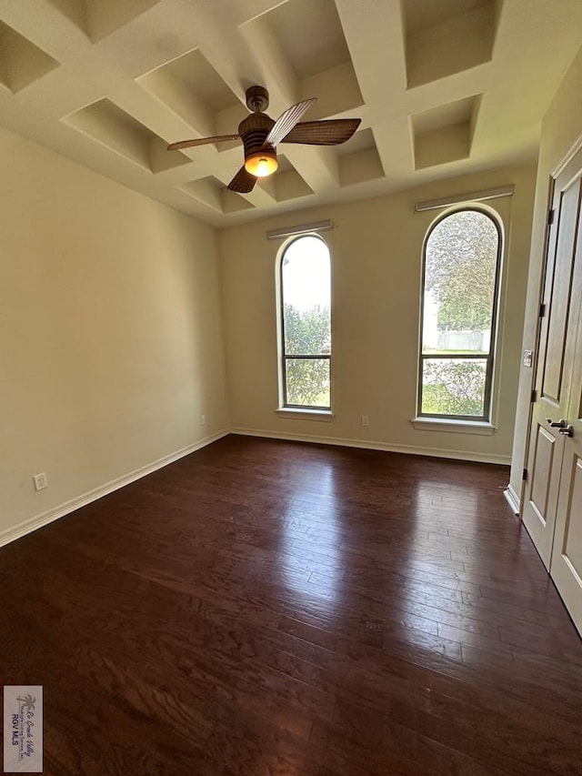 spare room with beam ceiling, ceiling fan, dark wood-type flooring, and coffered ceiling