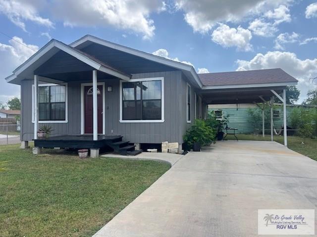 1327 W Johnson Ave, Harlingen, TX 78550 - view of front of property with a front yard, driveway, an attached carport, and covered porch