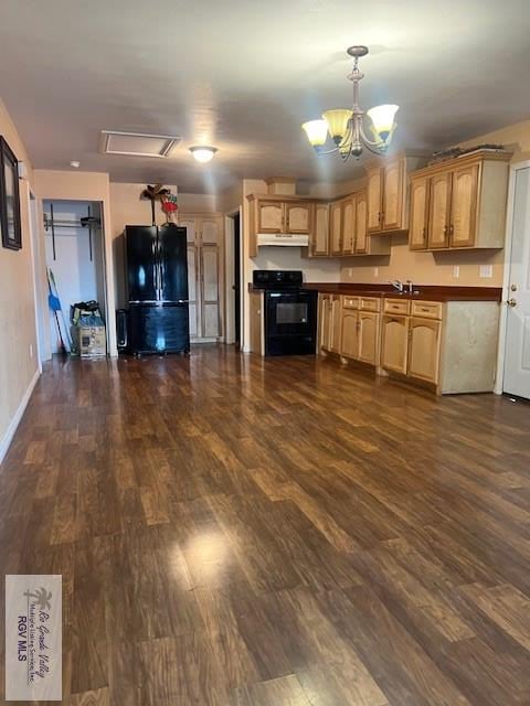 1327 W Johnson Ave, Harlingen, TX 78550 - kitchen with black appliances, under cabinet range hood, a chandelier, and dark wood-style flooring