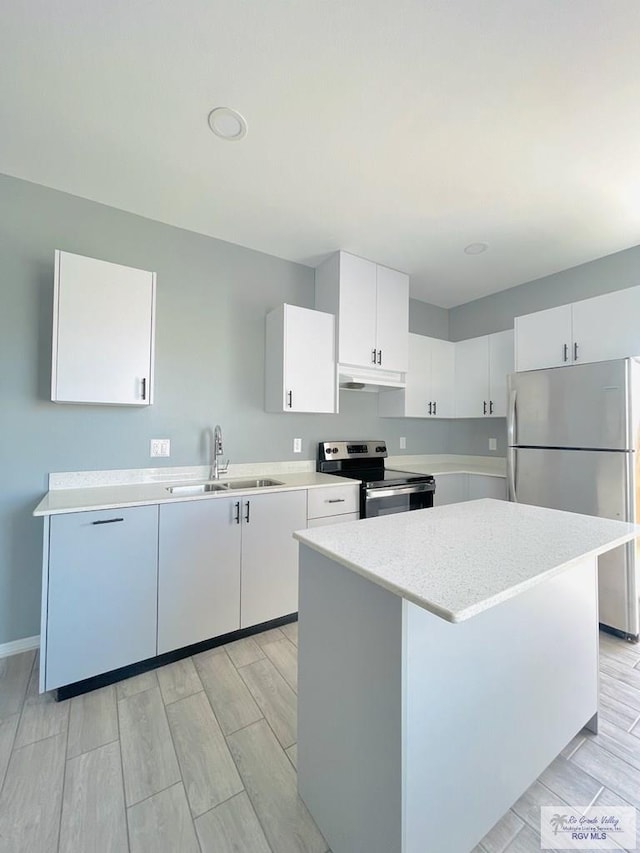 kitchen featuring white cabinetry, sink, light wood-type flooring, and appliances with stainless steel finishes