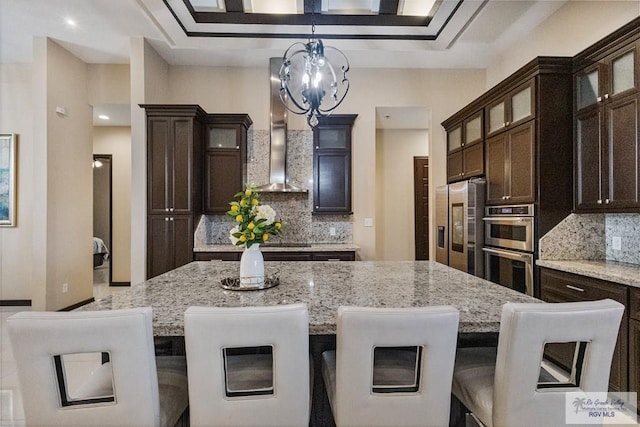 2540 Los Portales Dr, Brownsville, TX 78526 - kitchen featuring appliances with stainless steel finishes, tasteful backsplash, a chandelier, and light stone counters