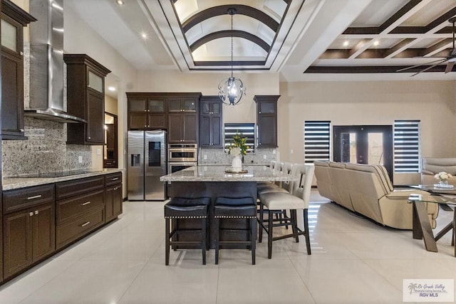 2540 Los Portales Dr, Brownsville, TX 78526 - kitchen with appliances with stainless steel finishes, wall chimney range hood, open floor plan, light tile patterned flooring, and coffered ceiling