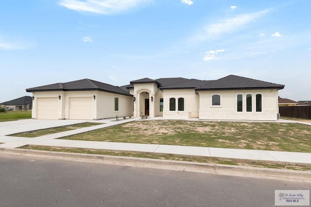 5407 Common Ln, Weslaco, TX 78596 - view of front facade featuring an attached garage, concrete driveway, stucco siding, a front lawn, and stone siding