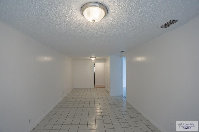 802 California St, Harlingen, TX 78552 - hallway with visible vents, a textured ceiling, and light tile patterned flooring