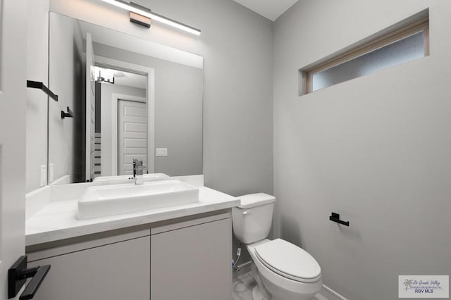 2009 New Combes Rd, Harlingen, TX 78550 - half bathroom with vanity, toilet, baseboards, and marble finish flooring
