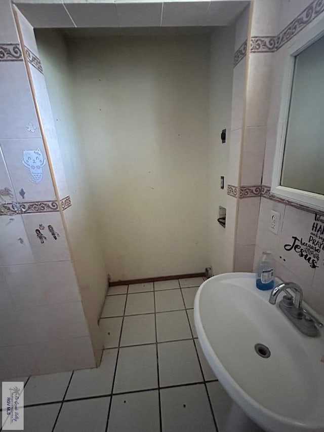 bathroom featuring tile patterned floors, sink, and tile walls