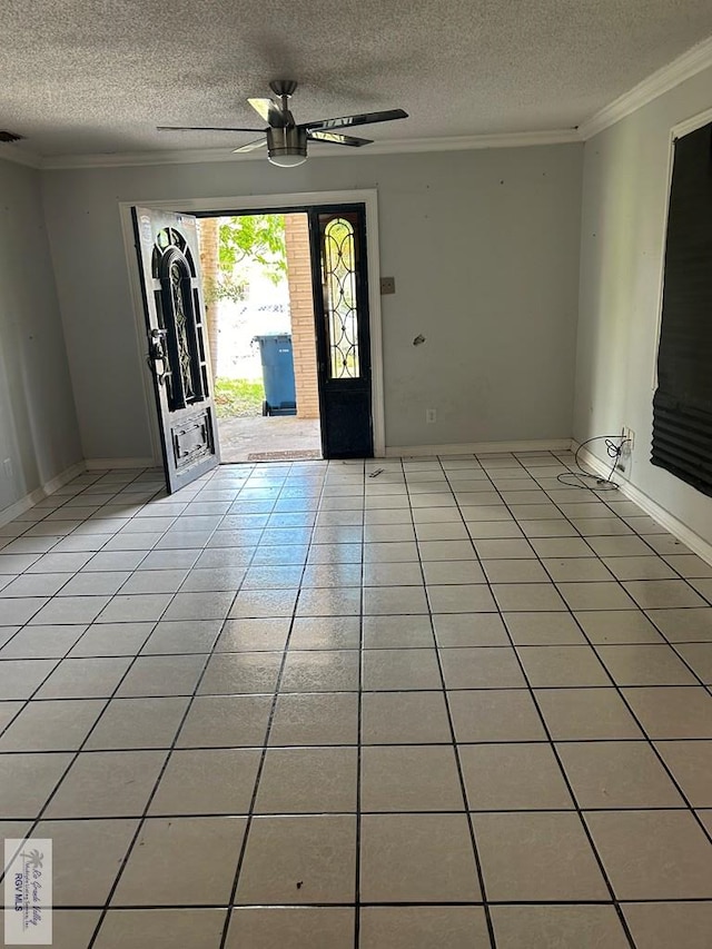 tiled entrance foyer featuring ceiling fan, ornamental molding, and a textured ceiling