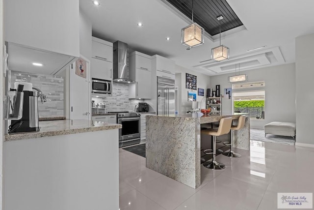 5483 Lovers Ln, Brownsville, TX 78526 - kitchen featuring decorative backsplash, appliances with stainless steel finishes, white cabinets, light tile patterned flooring, and wall chimney range hood