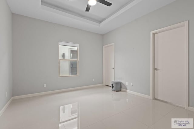 5483 Lovers Ln, Brownsville, TX 78526 - unfurnished room featuring tile patterned floors, ceiling fan, and a tray ceiling