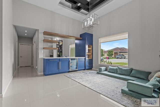 5483 Lovers Ln, Brownsville, TX 78526 - living area featuring a towering ceiling, light tile patterned floors, beverage cooler, and a chandelier