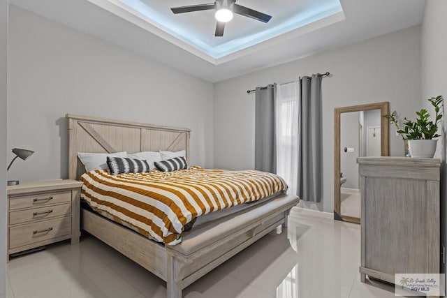 5483 Lovers Ln, Brownsville, TX 78526 - bedroom with a tray ceiling, light tile patterned floors, and a ceiling fan