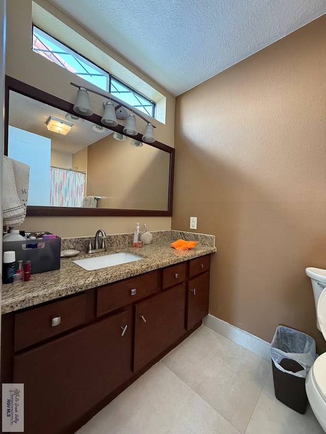 2100 W San Marcelo Blvd Unit 216, Brownsville, TX 78526 - bathroom featuring toilet, baseboards, vanity, and a textured ceiling