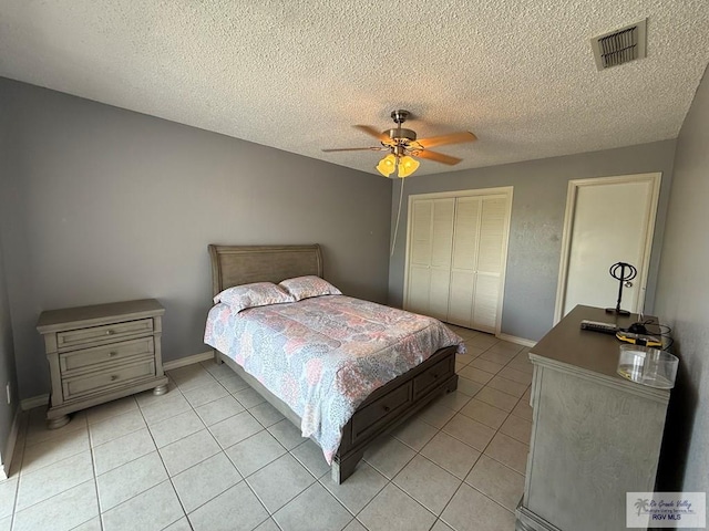 2100 W San Marcelo Blvd Unit 216, Brownsville, TX 78526 - bedroom featuring a closet, light tile patterned flooring, ceiling fan, baseboards, and a textured ceiling