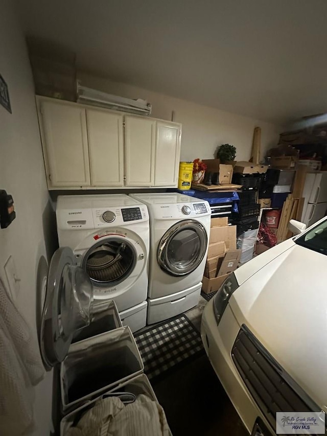 laundry room with washing machine and dryer and cabinets