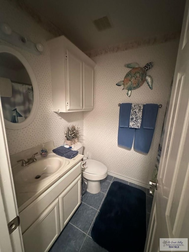 bathroom featuring toilet, tile patterned flooring, and vanity