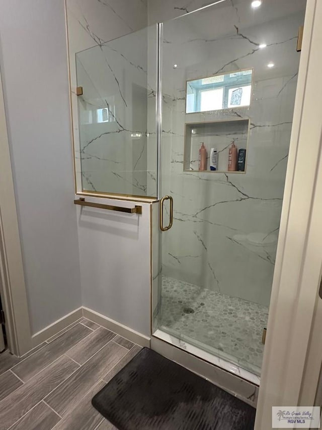 bathroom featuring a shower with door