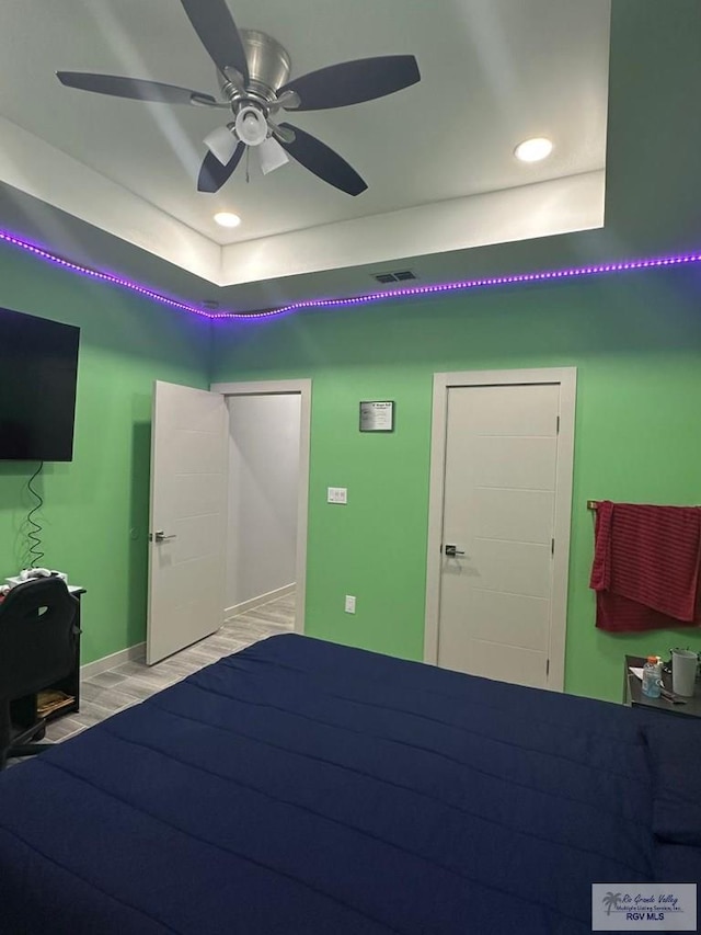 unfurnished bedroom featuring a raised ceiling and ceiling fan