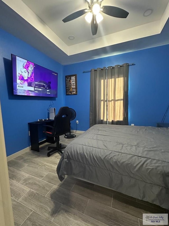 bedroom with a tray ceiling and ceiling fan