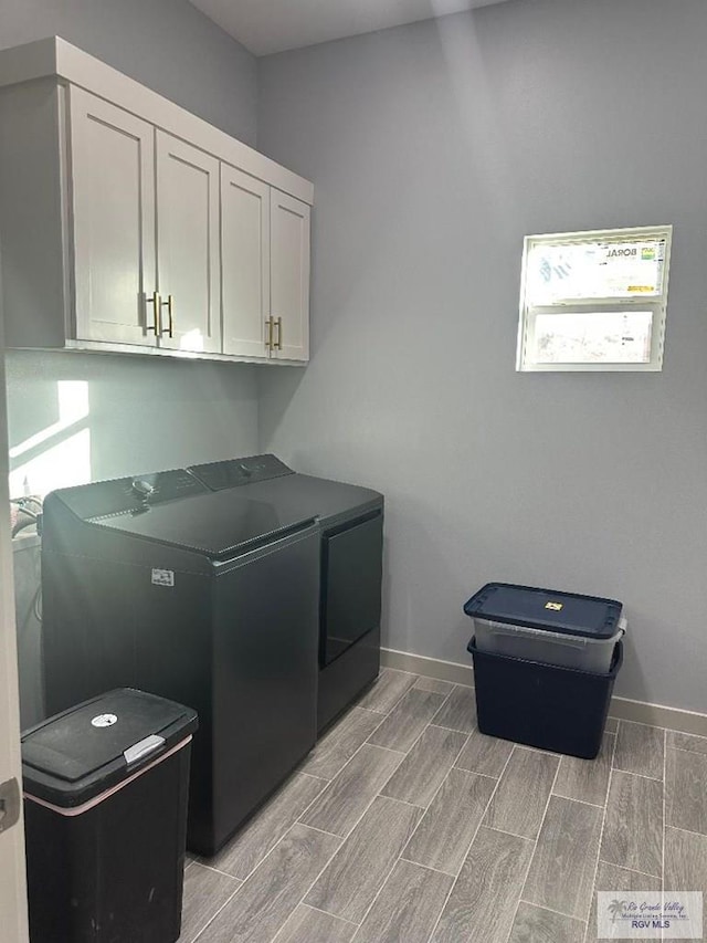 laundry room with washer and clothes dryer and cabinets