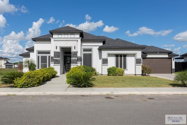 view of front of house featuring a garage and a front lawn