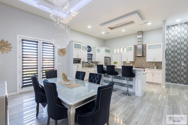 dining room featuring sink, light hardwood / wood-style flooring, and a chandelier