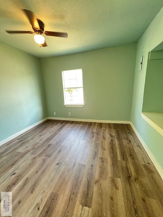 spare room featuring ceiling fan, hardwood / wood-style floors, and a textured ceiling