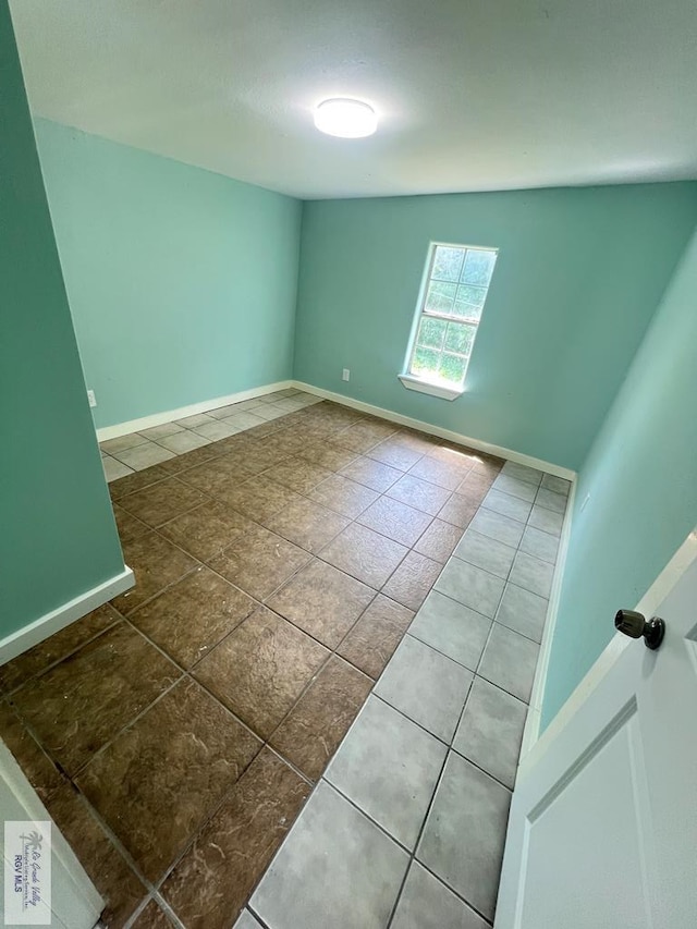 spare room with tile patterned flooring and lofted ceiling