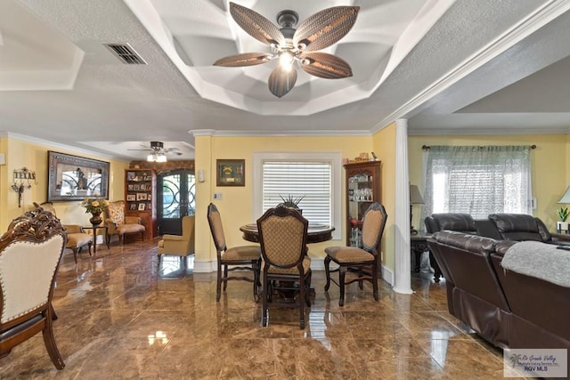 dining room with a raised ceiling, ceiling fan, a healthy amount of sunlight, and ornamental molding