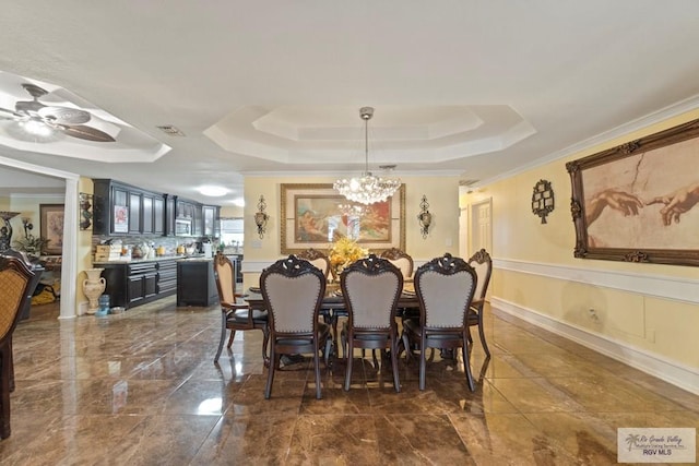 dining space featuring ceiling fan with notable chandelier, a raised ceiling, and ornamental molding