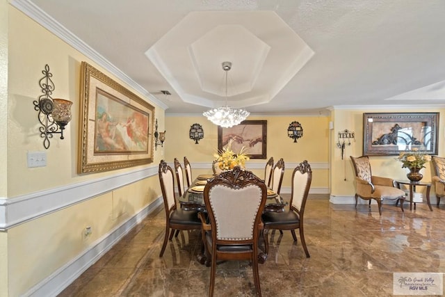 dining room featuring ornamental molding, a tray ceiling, and a notable chandelier