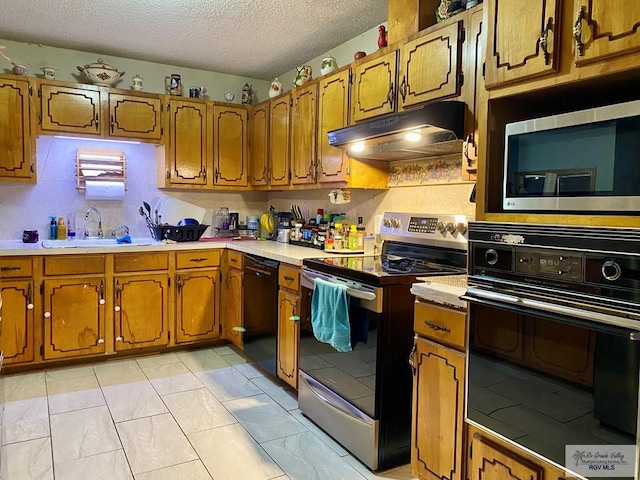 kitchen with sink, light tile patterned floors, a textured ceiling, and black appliances