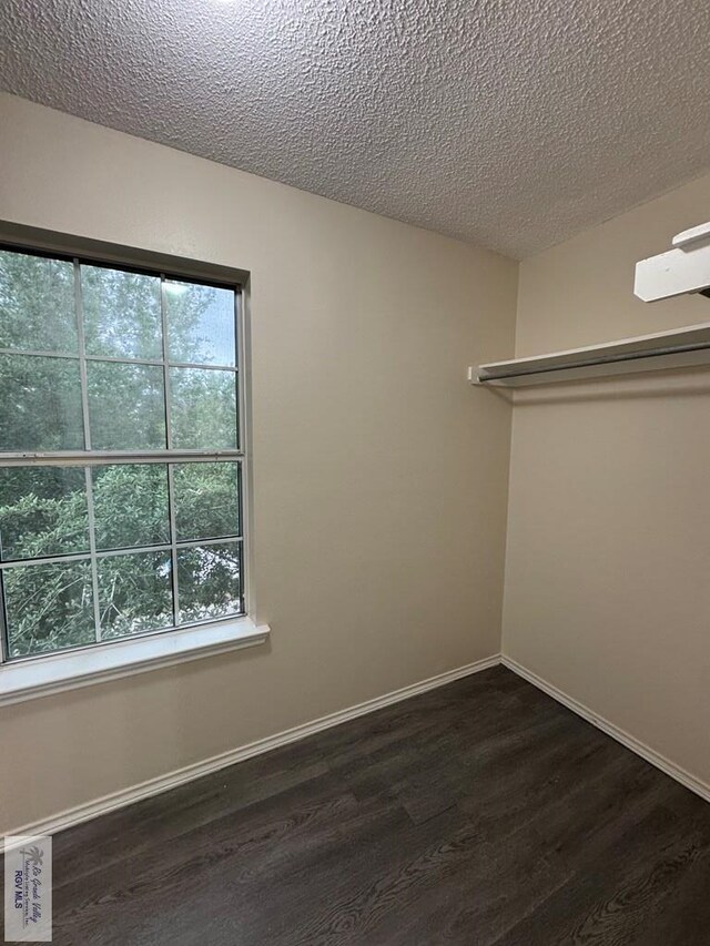 1072 Vamonos Dr, Brownsville, TX 78526 - spare room with dark wood-style flooring, baseboards, and a textured ceiling