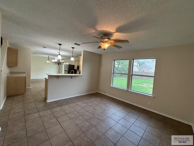 1072 Vamonos Dr, Brownsville, TX 78526 - unfurnished living room featuring a chandelier, tile patterned floors, a textured ceiling, a ceiling fan, and baseboards