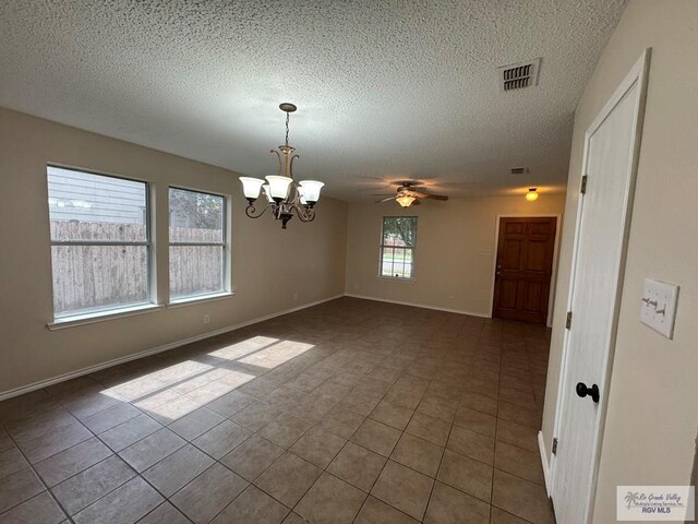 1072 Vamonos Dr, Brownsville, TX 78526 - tiled empty room with a chandelier, a textured ceiling, ceiling fan, and baseboards