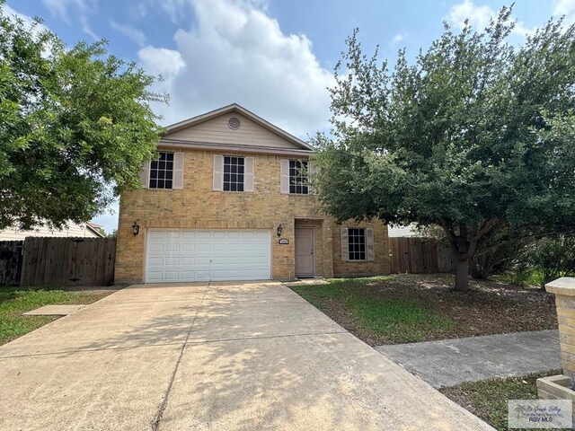 1072 Vamonos Dr, Brownsville, TX 78526 - view of front of house with an attached garage, concrete driveway, fence, and brick siding