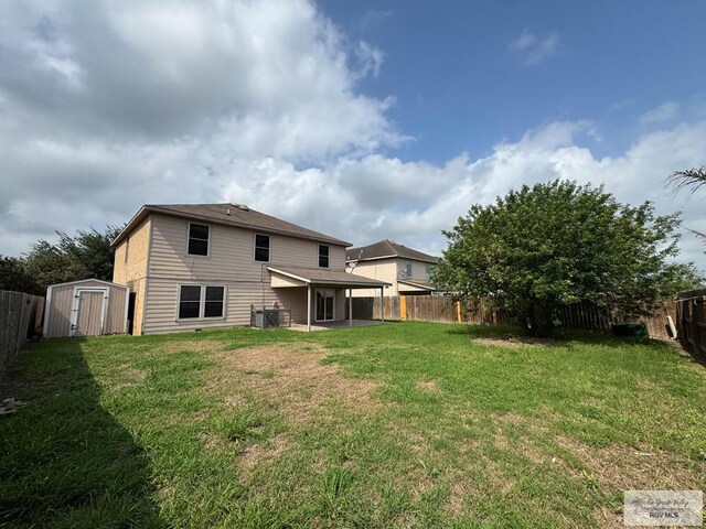 1072 Vamonos Dr, Brownsville, TX 78526 - back of property with a storage shed, a patio area, an outbuilding, and central AC