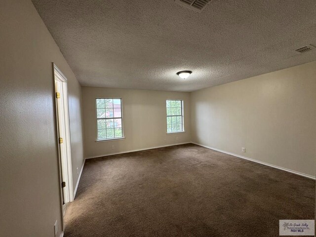 1072 Vamonos Dr, Brownsville, TX 78526 - spare room featuring baseboards, a textured ceiling, and dark colored carpet