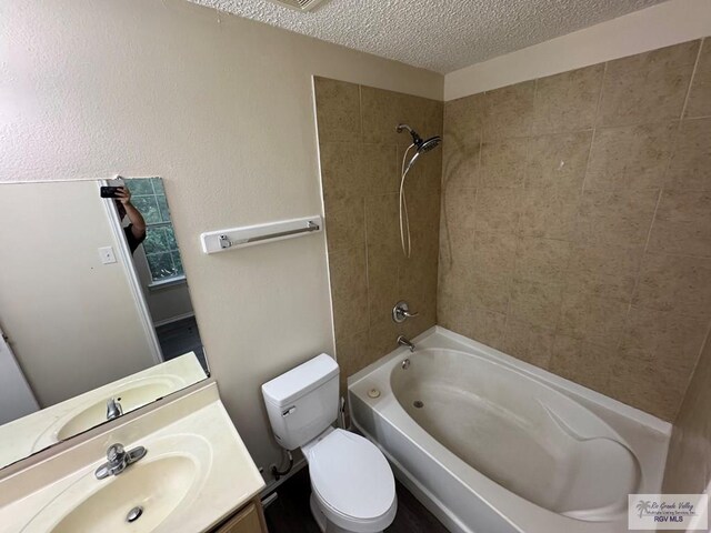 1072 Vamonos Dr, Brownsville, TX 78526 - bathroom featuring tub / shower combination, a textured ceiling, vanity, and toilet