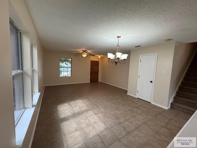 1072 Vamonos Dr, Brownsville, TX 78526 - unfurnished room with a textured ceiling, a chandelier, tile patterned floors, ceiling fan, and stairway