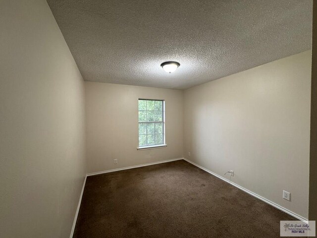 1072 Vamonos Dr, Brownsville, TX 78526 - spare room with baseboards, dark carpet, and a textured ceiling