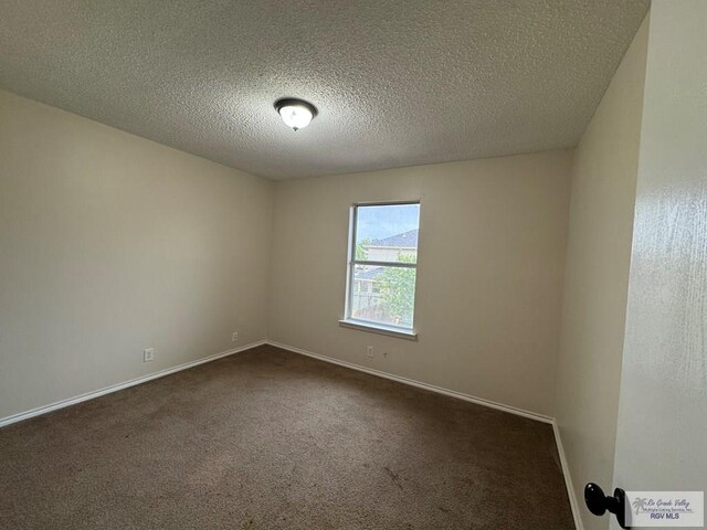 1072 Vamonos Dr, Brownsville, TX 78526 - spare room with dark carpet, baseboards, and a textured ceiling