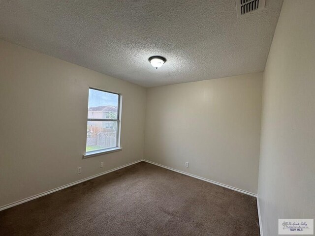 1072 Vamonos Dr, Brownsville, TX 78526 - spare room featuring dark colored carpet, a textured ceiling, and baseboards