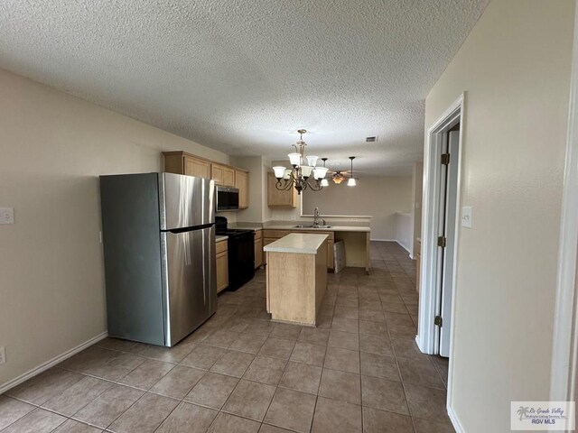1072 Vamonos Dr, Brownsville, TX 78526 - kitchen with appliances with stainless steel finishes, a peninsula, a sink, light countertops, and a chandelier