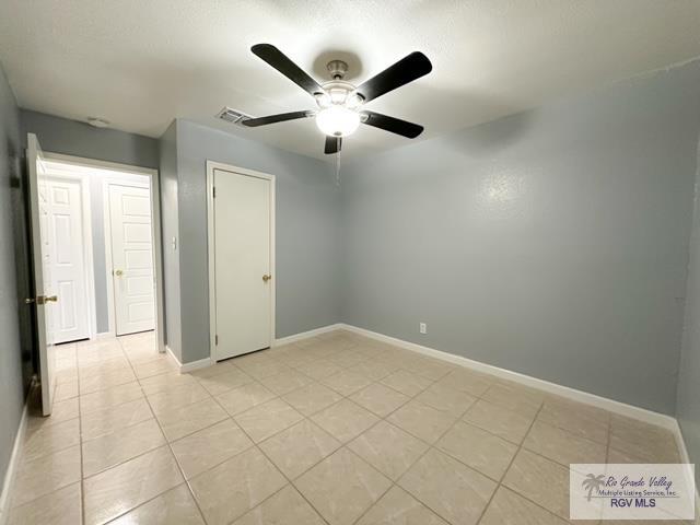 spare room featuring ceiling fan and light tile patterned floors