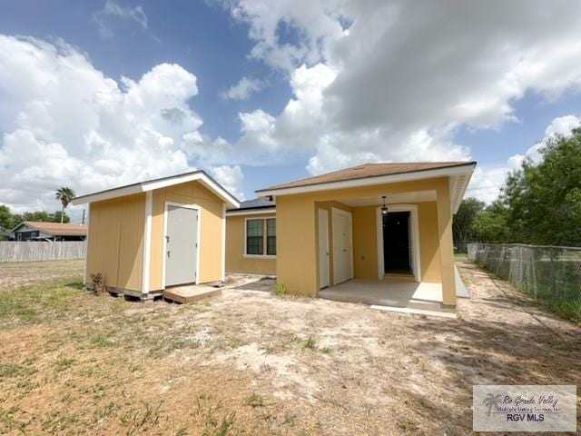 back of house featuring a storage shed