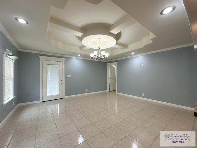 unfurnished room featuring a tray ceiling, crown molding, light tile patterned flooring, and a notable chandelier