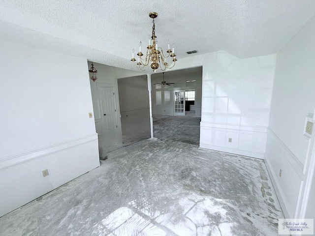 unfurnished dining area featuring a textured ceiling and ceiling fan with notable chandelier