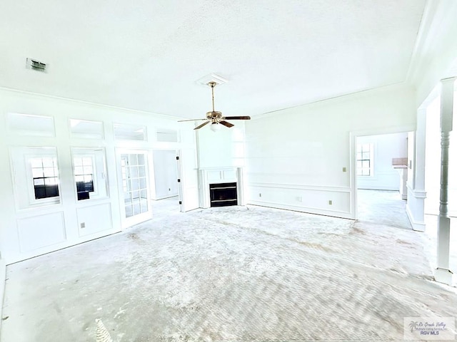 unfurnished living room with ceiling fan, a healthy amount of sunlight, and crown molding