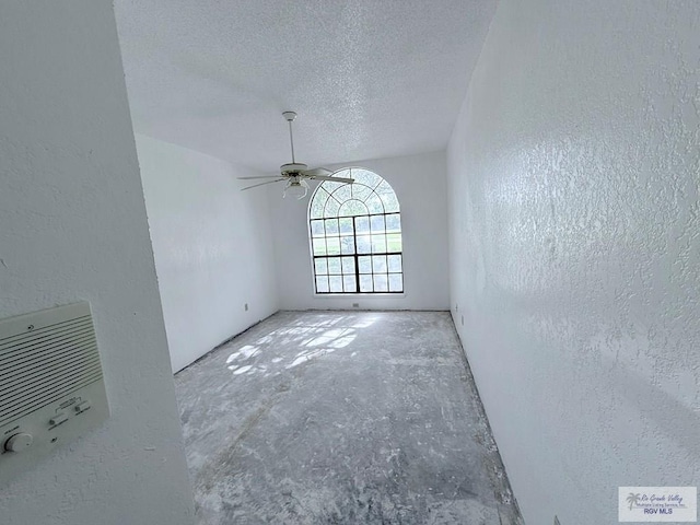 interior space with ceiling fan and a textured ceiling